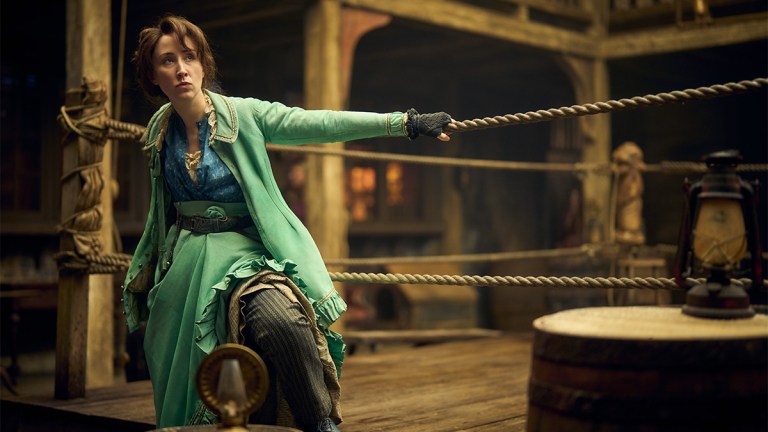 Erin Doherty in a blue Victorian dress next to a boxing ring