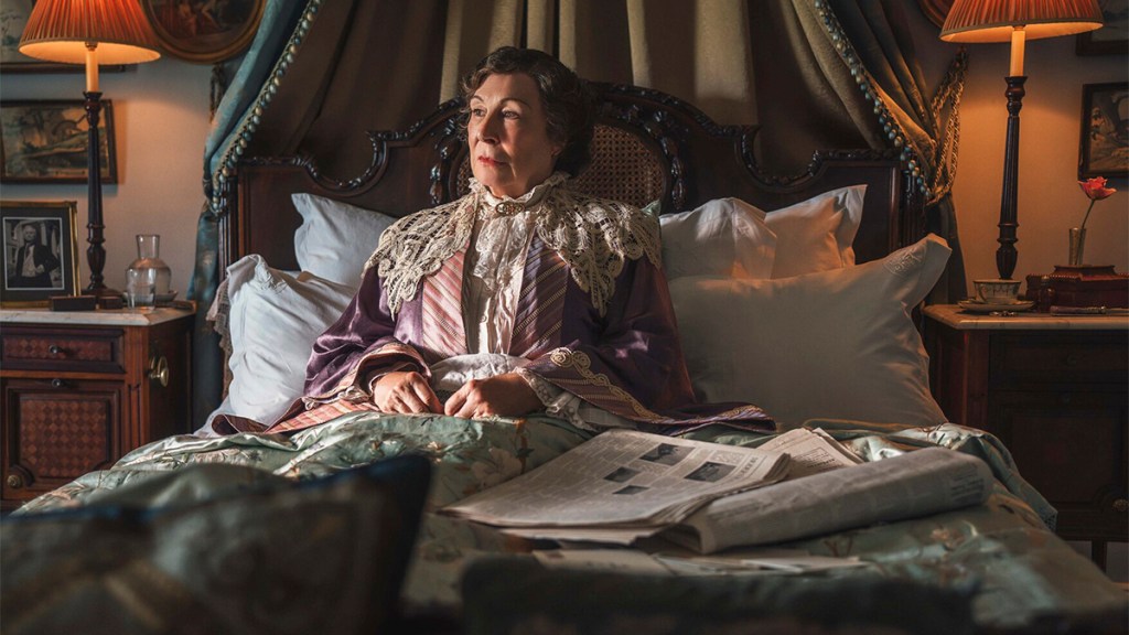 Anjelica Huston sitting upright in bed in Towards Zero