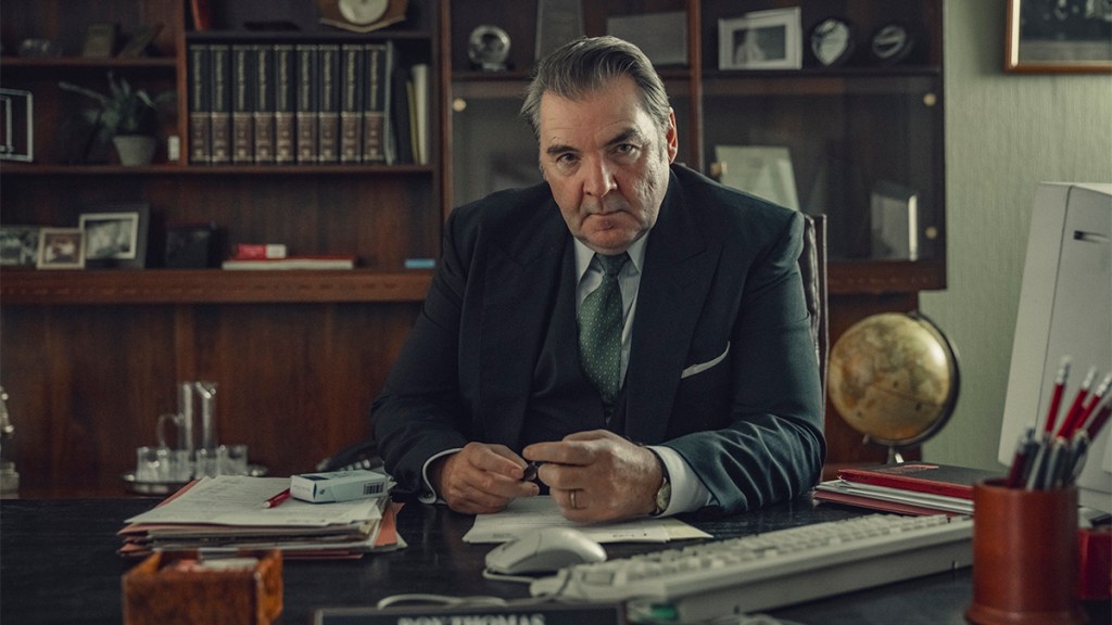 A man in a three-piece suit sitting behind an office desk in Netflix&rsquo;s Toxic Town
