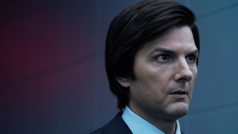 Adam Scott in Severance stands in front of a wall with a red and gray background