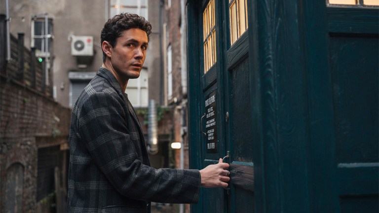 Jonah Hauer-King as Conrad Clark standing next to the TARDIS in Doctor Who episode "Lucky Day"