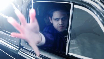 Isaac Ordonez shooting electricity from his fingertips in a car as Pugsley Addams in the new Wednesday season 2 trailer
