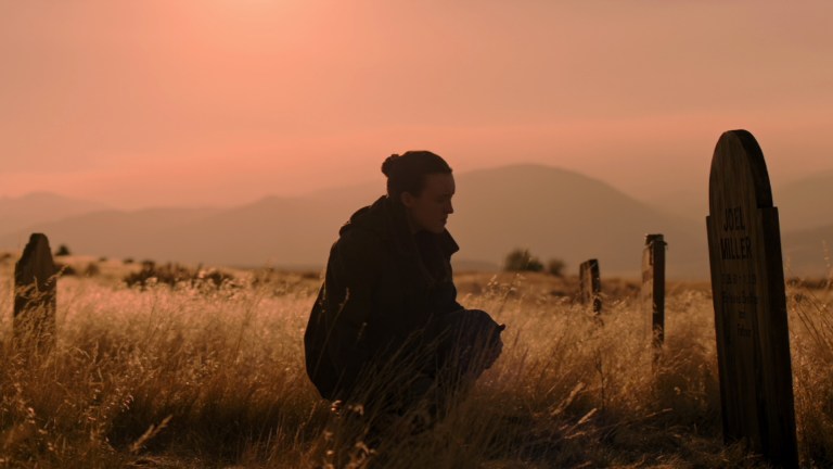 Ellie (Bella Ramsey) kneels over Joel's grave in The Last of Us season 2