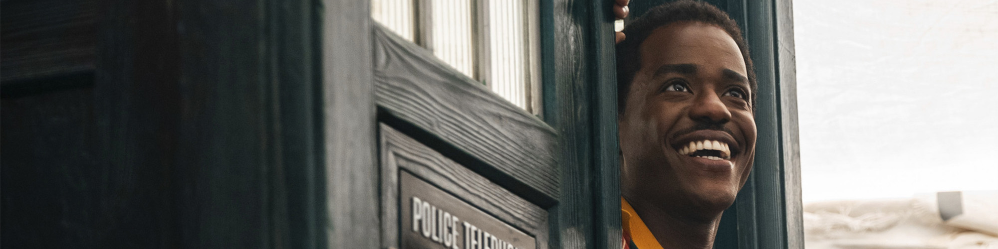 A smiling Ncuti Gatwa emerging from the TARDIS door in Doctor Who season 2 episode "The Story & The Engine"
