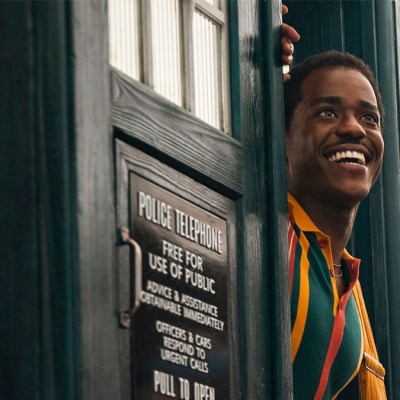 A smiling Ncuti Gatwa emerging from the TARDIS door in Doctor Who season 2 episode "The Story & The Engine"