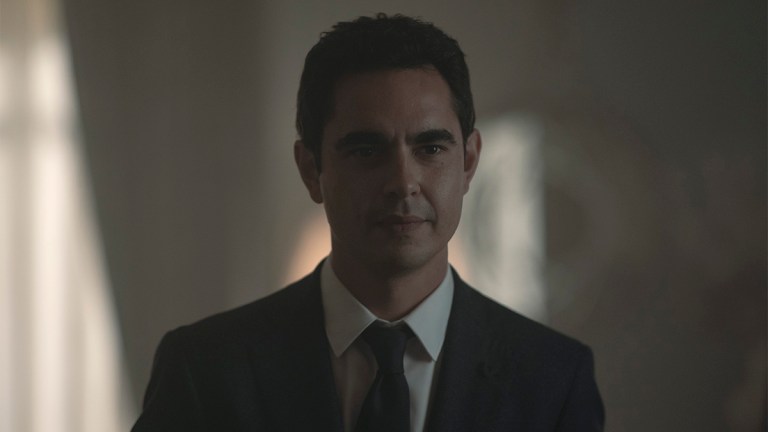 Max Minghella wearing a black suit and tie and white shirt in The Handmaid's Tale season 6