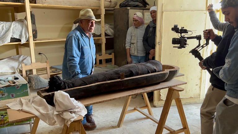 Zahi Hawass over a mummy in Man with the hat